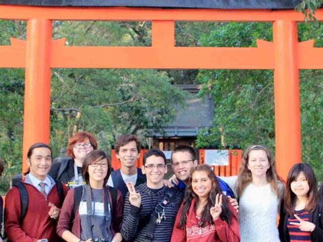 澳门六合彩开奖结果走势图 students pose in front of a shinto shrine in japan.
