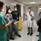 Doctor in a white coat talks with medical students in a hospital