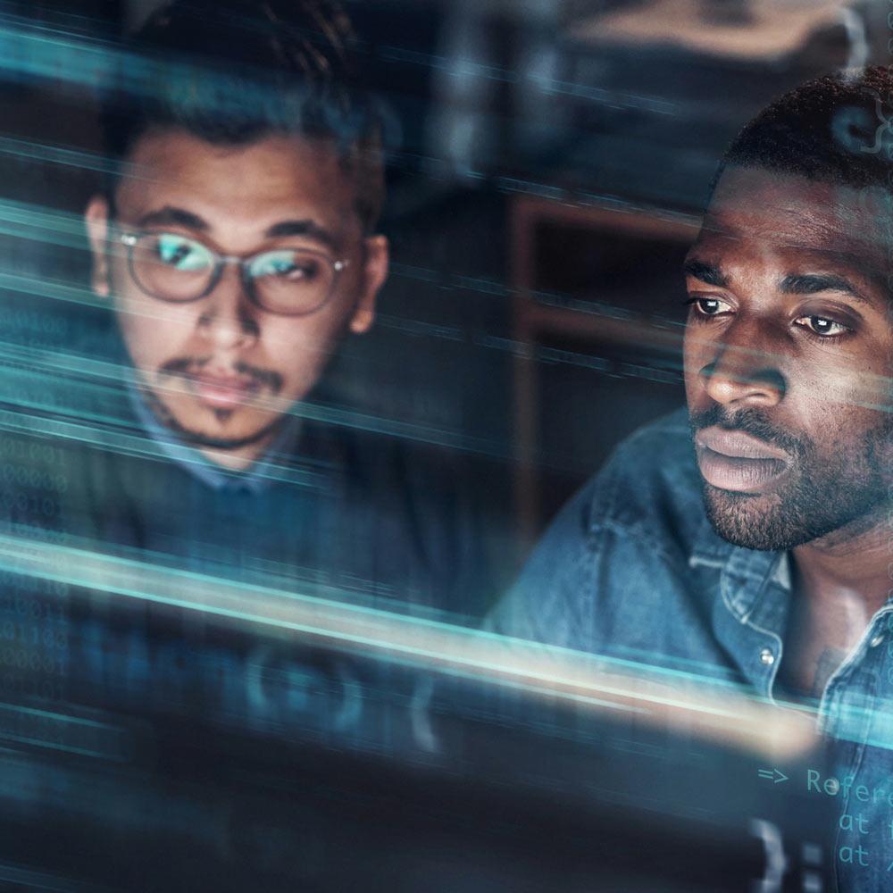 Two men look at a screen with code superimposed over the top of them