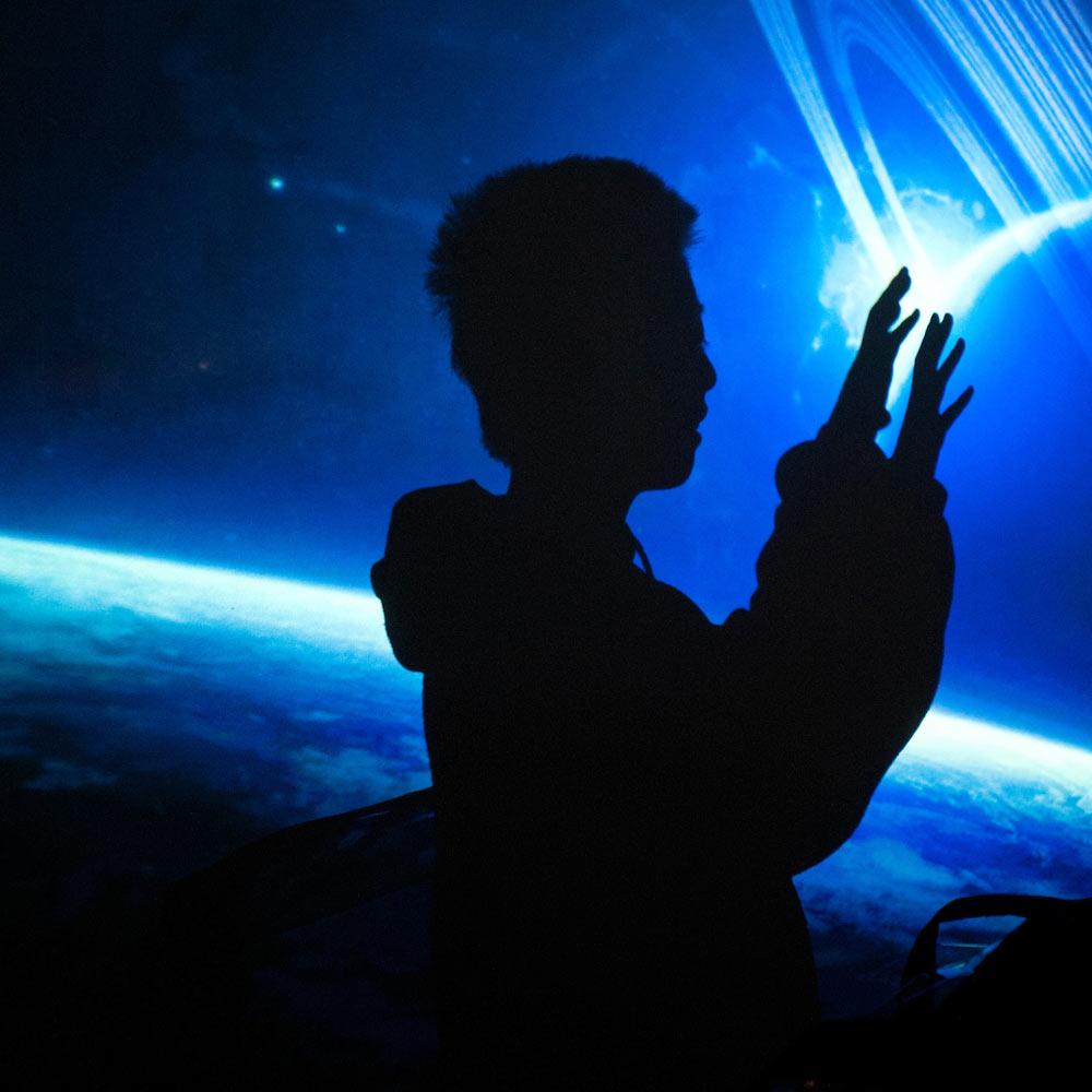 A child interacts with a virtual universe exhibit